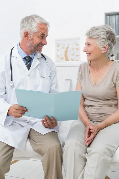 Male doctor and senior patient with reports — Stock Photo, Image