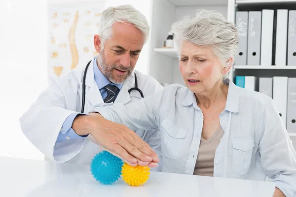 Läkare med äldre patient med stress buster bollar — Stockfoto