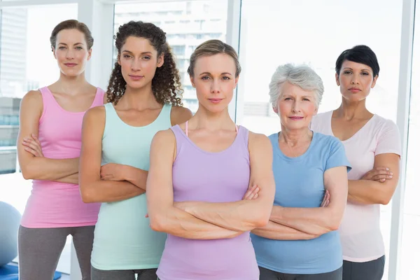 Självsäkra kvinnor med armar korsade i yogaklass — Stockfoto