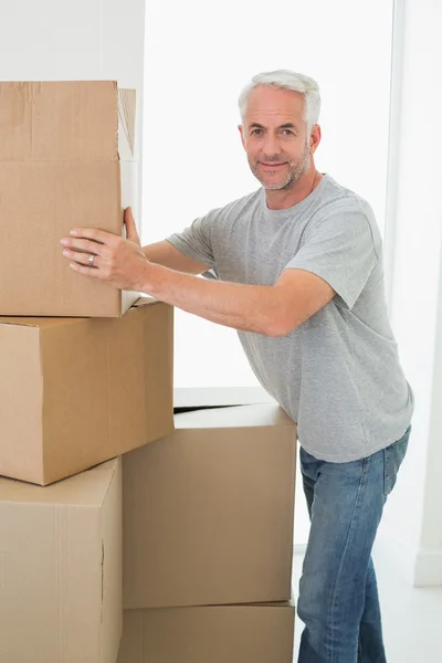 Happy man moving cardboard moving boxes — Stock Photo, Image