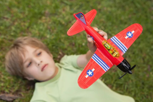 Menino brincando com um avião de brinquedo — Fotografia de Stock