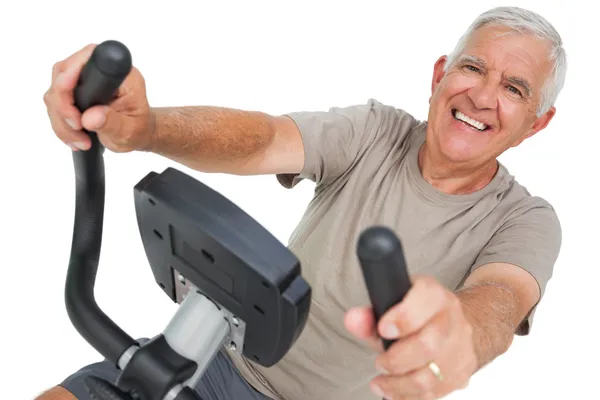 Happy senior man on stationary bike — Stock Photo, Image