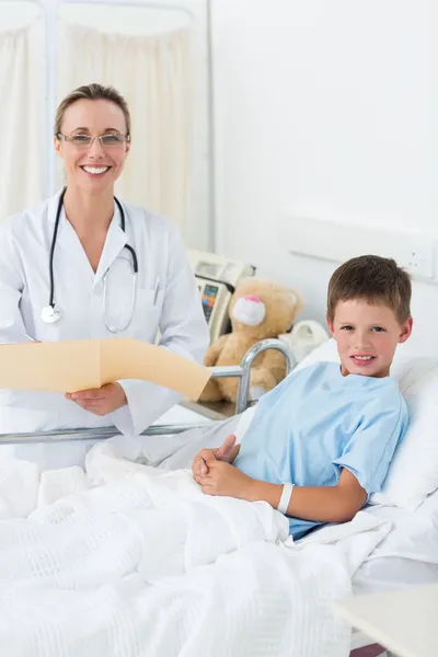 Doutor com menino na cama do hospital — Fotografia de Stock