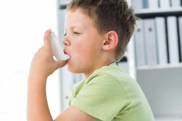 Boy using an asthma inhaler in clinic — Stock Photo, Image