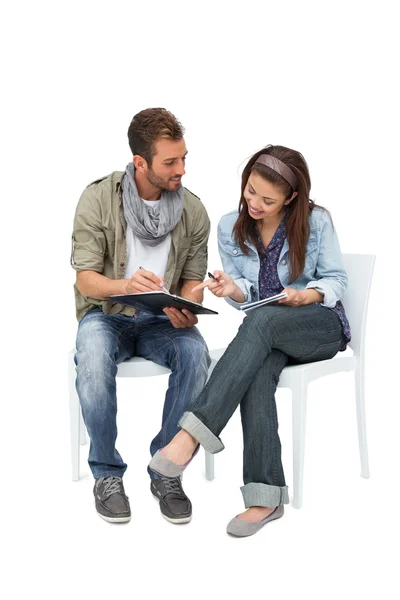 Couple writing in notepads — Stock Photo, Image