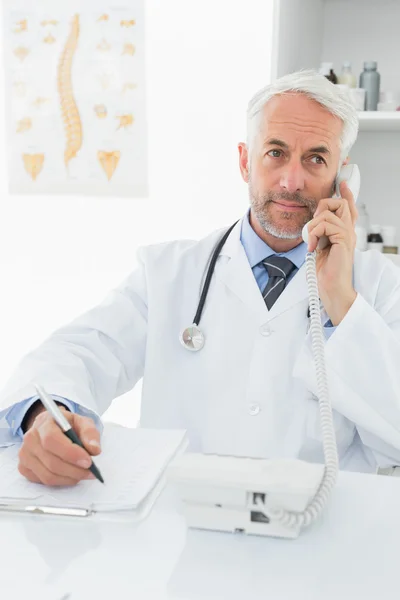 Male doctor writing reports while on call — Stock Photo, Image