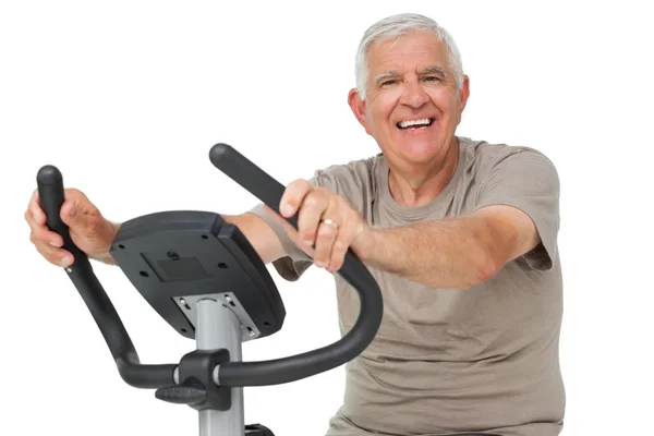 Счастливый пожилой человек на стационарном велосипеде — стоковое фото