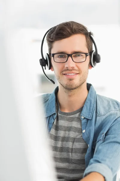 Retrato de un hombre sonriente con auriculares usando computadora —  Fotos de Stock