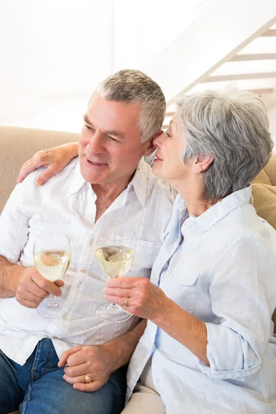 Äldre par sitter på soffan med vitt vin — Stockfoto