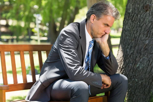 Deprimerad affärsman sitter på bänken — Stockfoto