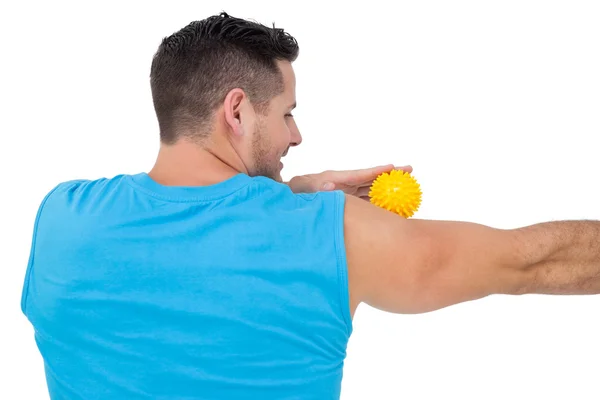 Achteraanzicht van een inhoud jonge man houden stressbal — Stockfoto