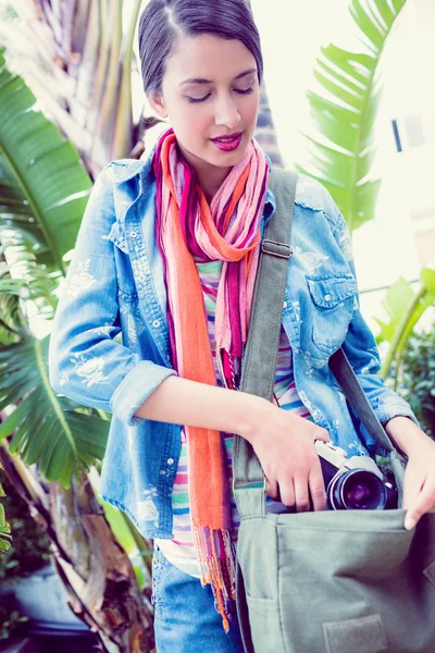 Woman taking camera out from her bag — Stock Photo, Image