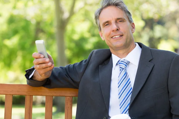 Zakenman met cellphone in park — Stockfoto