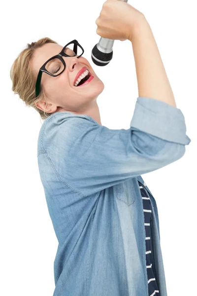 Beautiful young woman singing into a microphone — Stock Photo, Image