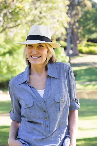 Mulher feliz usando chapéu de sol no parque — Fotografia de Stock