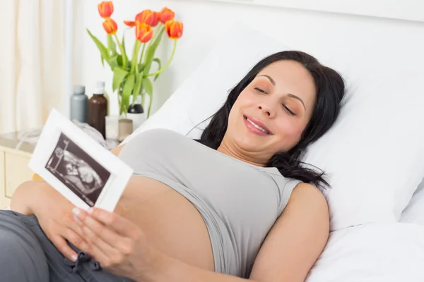 妊娠中の女性の腹部超音波検査にて報告を見て — ストック写真