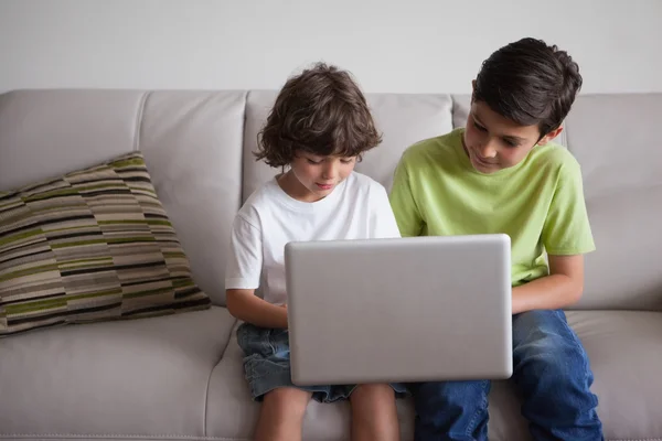 Αγόρια χρησιμοποιώντας φορητό υπολογιστή στο σαλόνι — Φωτογραφία Αρχείου