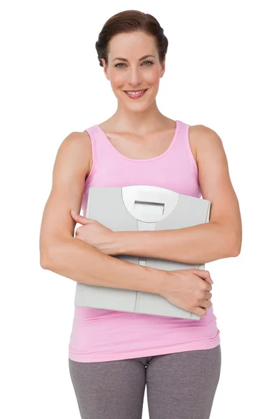 Portrait of a smiling young woman with weight scale — Stock Photo, Image