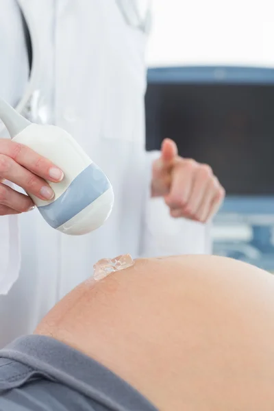 Doctor using ultrasound on belly of pregnant woman — Stock Photo, Image