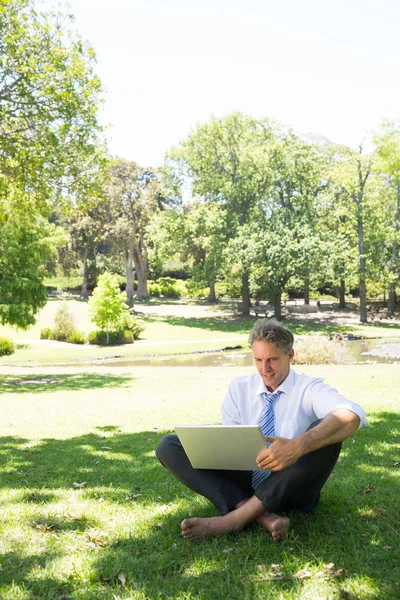 Biznesmen korzysta z laptopa w parku — Zdjęcie stockowe