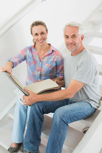 Casal feliz escolhendo amostras de tapete juntos — Fotografia de Stock