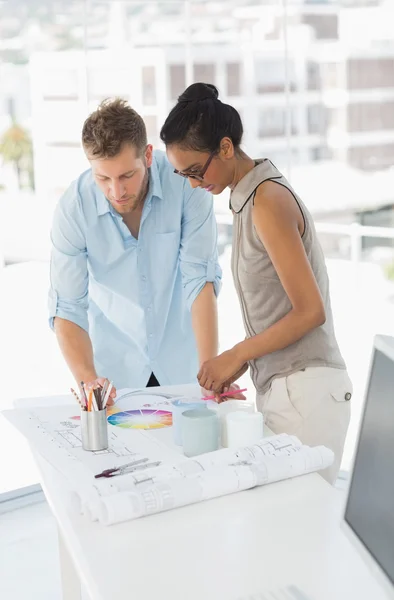 Interior designers looking at colour wheel and blueprints — Stock Photo, Image
