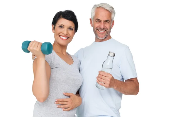 Happy fit couple with dumbbell and water bottle — Stock Photo, Image