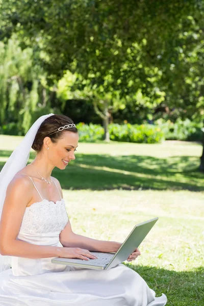 新娘在花园的草地上使用便携式计算机 — 图库照片