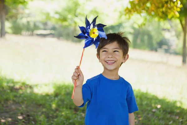 Fröhlicher süßer kleiner Junge mit Windrad im Park — Stockfoto