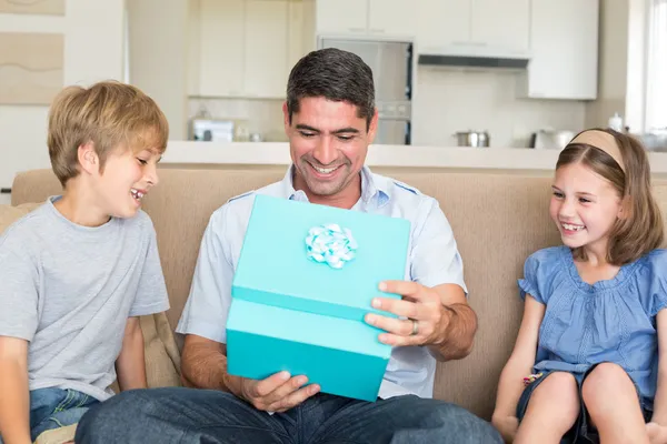 Father opening gift given by children — Stock Photo, Image