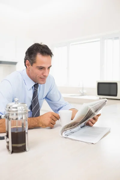 Mann mit Kaffeetasse liest Zeitung — Stockfoto