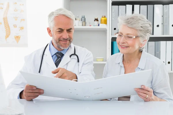 Lekarz z pacjentki czytanie raportów — Zdjęcie stockowe