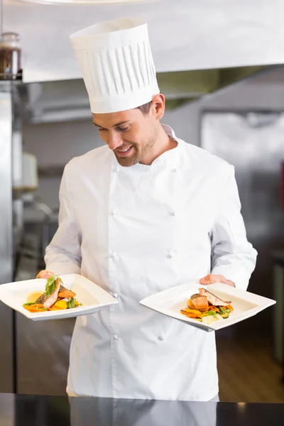 Sorrindo chef masculino com comida cozida na cozinha — Fotografia de Stock