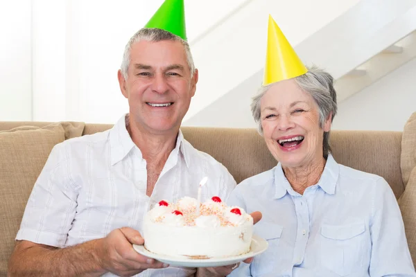 Seniorenpaar sitzt auf Couch und feiert Geburtstag — Stockfoto