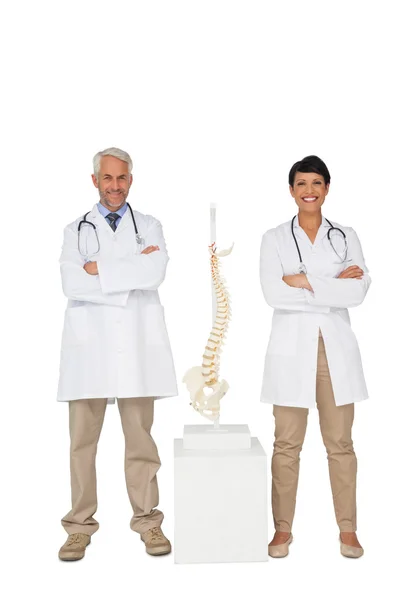 Médicos sorridentes com modelo de esqueleto — Fotografia de Stock