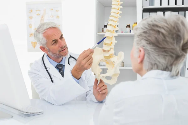 Médecin masculin expliquant la colonne vertébrale au patient âgé — Photo