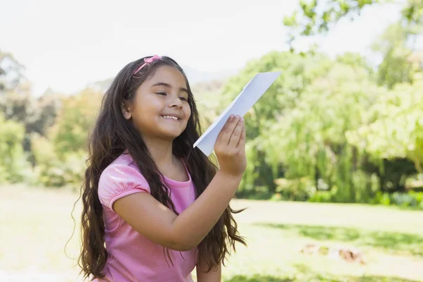 Chica jugando con un avión de papel en el parque —  Fotos de Stock