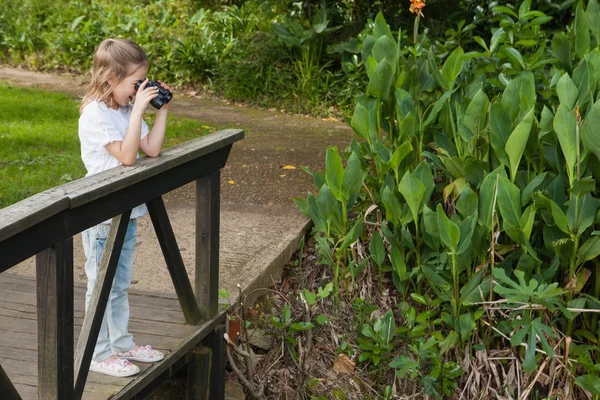 Meisje op zoek door middel van verrekijkers in park — Stockfoto