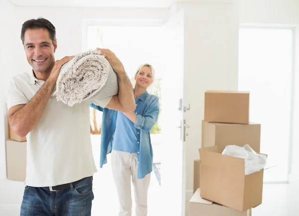 Casal transportando tapete laminado — Fotografia de Stock