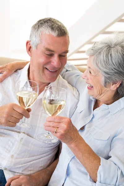 Casal sênior sentado no sofá tendo vinho branco — Fotografia de Stock