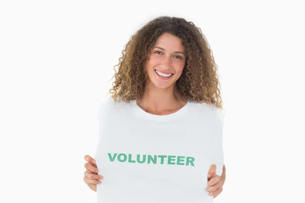 Uśmiechnięty, wolontariuszy pokazano jej tshirt do aparatu — Zdjęcie stockowe