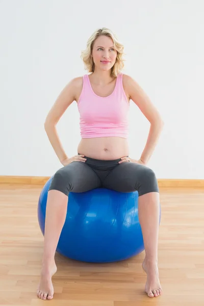 運動ボールの上に座って思考金髪妊娠中の女性 — ストック写真