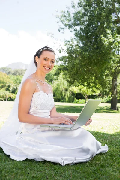Bride using laptop in garden — Stock Photo, Image