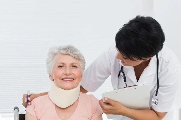 Arts in gesprek met een hogere patiënt met cervicale kraag — Stockfoto