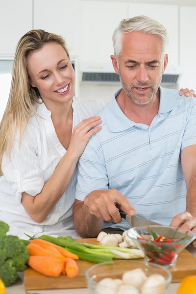 Affectionate couple preparing dinner together — Stock Photo, Image
