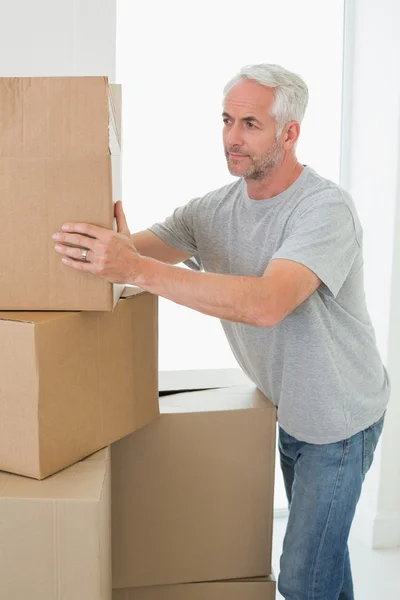Thoughtful man looking at cardboard moving boxes — Stock Photo, Image