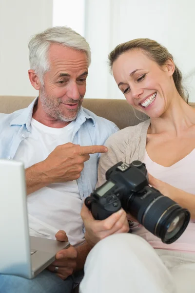 Coppia felice vedendo le loro foto sul computer portatile — Foto Stock