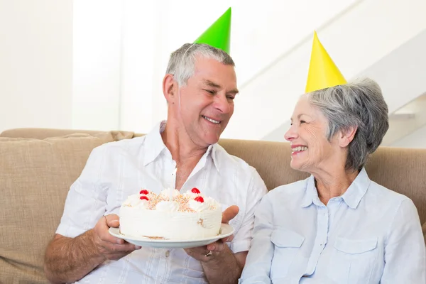 Oudere echtpaar zitten op de bank vieren een verjaardag — Stockfoto