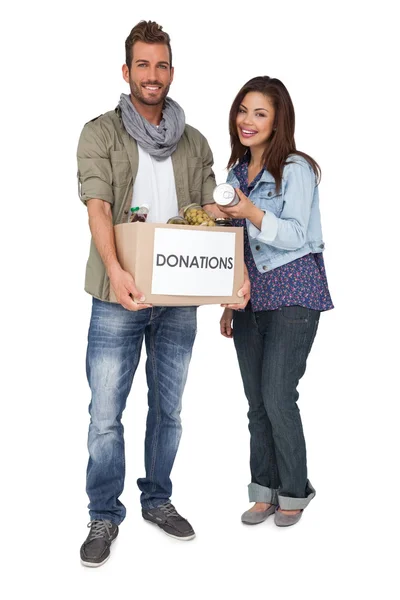 Pareja joven con caja de donaciones — Foto de Stock