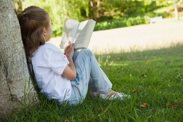 Mädchen liest Buch im Park — Stockfoto